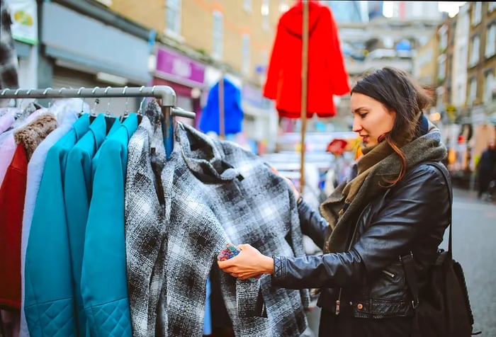 A woman inspects the coats on display at the flea market.