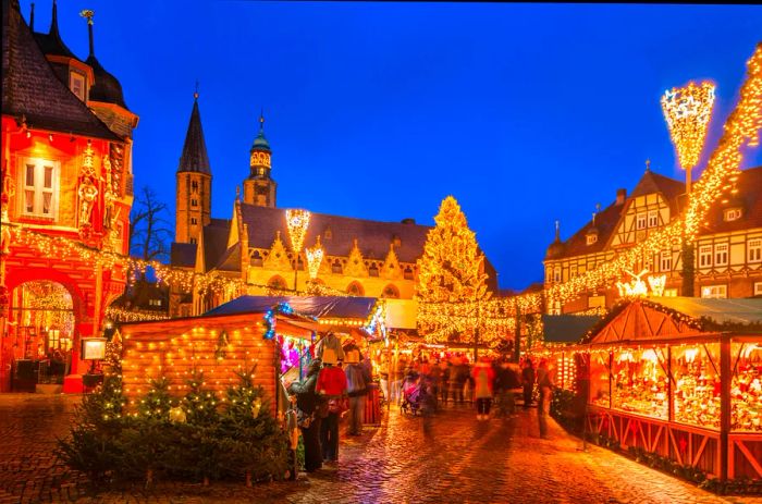 A picturesque view of the traditional Christmas market in the historic Market Square of Goslar, Germany at twilight.