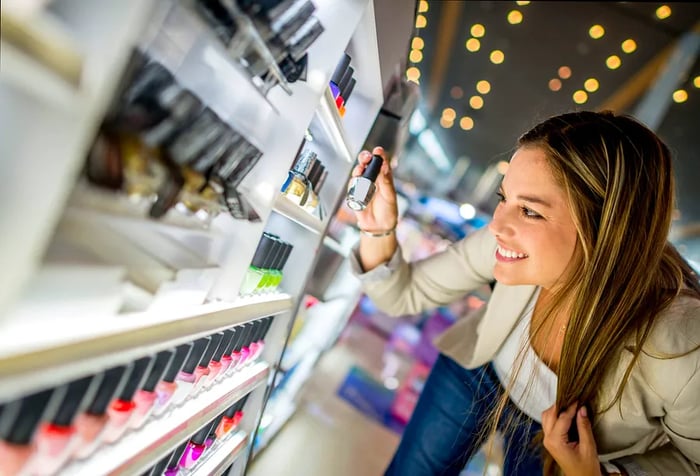 a woman happily purchasing cosmetics