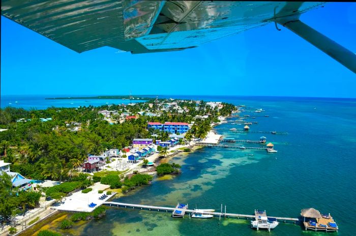 Aerial view of Caye Caulker with a plane wing in the foreground.