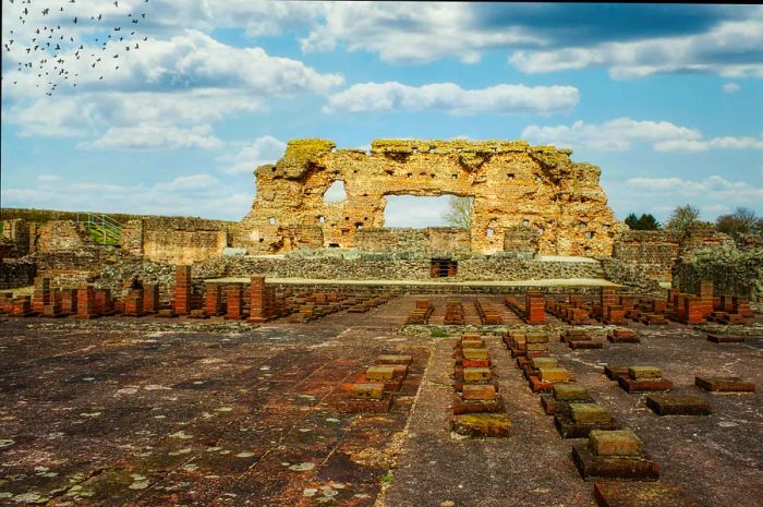 The remnants of an ancient Roman structure rise under a clear blue sky.