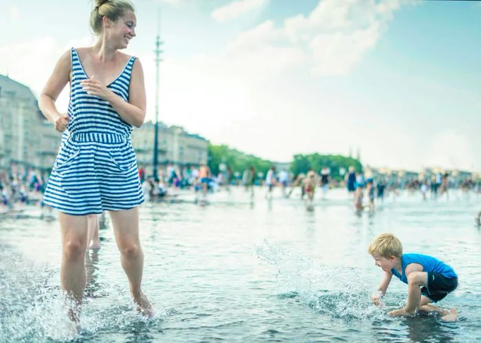 A mother and toddler playing in the Miroir d'Eau in Bordeaux