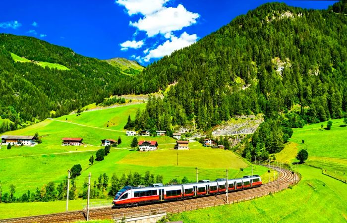 A regional train traverses the Brenner Railway, winding through the Austrian Alps.