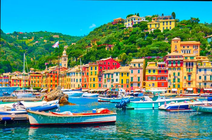 The brightly-colored houses around the harbor at Portofino, Italy, with boats gently bobbing in the sunlit waves.