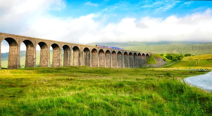 A train traversing the Ribblehead viaduct in the Yorkshire Dales, England.