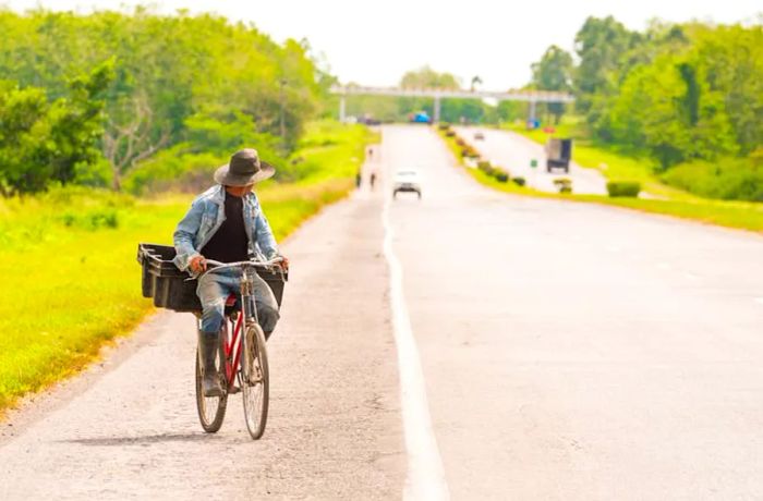 A cyclist pedals along a highway in Viñales, Pinar del Rio, Cuba