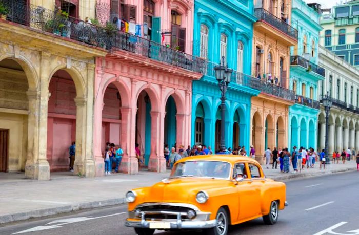 A classic American car parked in front of the vibrant buildings of Old Havana, Cuba