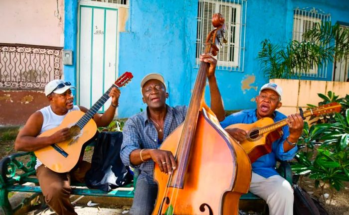 Three street musicians performing in the vibrant streets of Santiago de Cuba