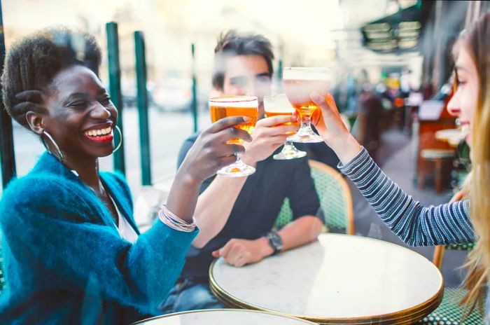 Three friends enjoying beers together at a French café/bar