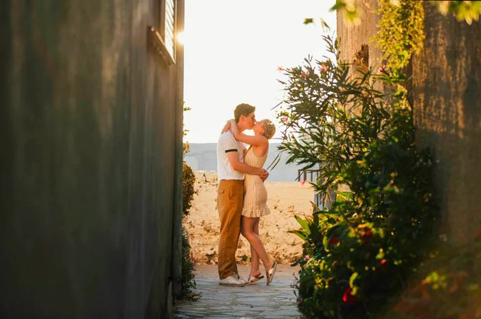 A loving couple enjoying a Mediterranean getaway, filled with joy, affection, and a carefree kiss in a charming alleyway.