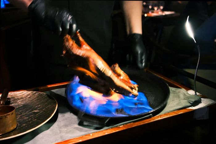 A long exposure captures the flambéing of Peking duck.