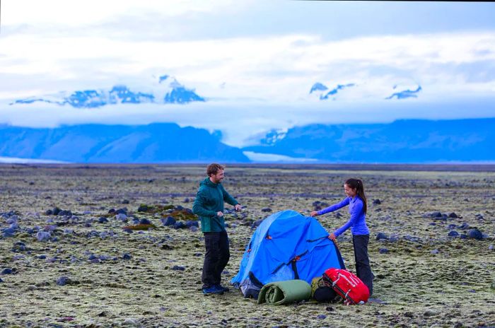 A couple setting up a tent after a hike in Iceland's rugged wilderness