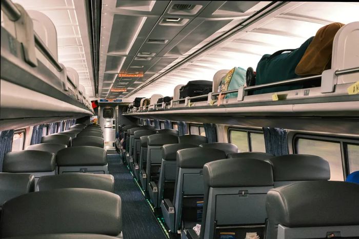 The interior of the Silver Meteor features blue seating and overhead luggage compartments.