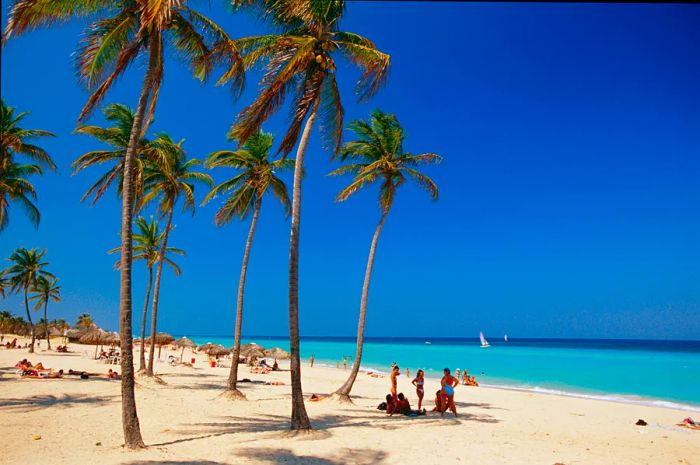 Visitors relax on the pristine sands of Santa María Beach in Cuba.