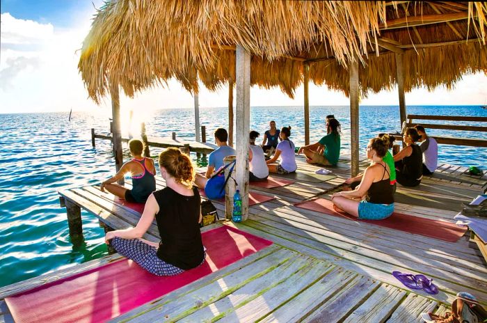 Yoga session on the dock of Caye Caulker island. Participants engage in yoga practices outdoors by the sea.