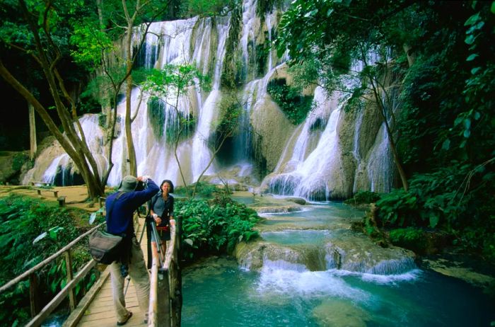 A man captures a moment of his wife by the waterfalls in Luang Prabang, Laos.