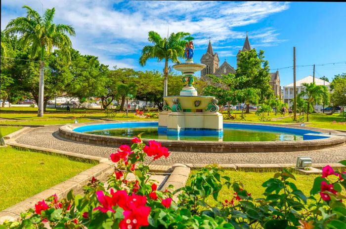 A view of flowers and trees surrounding the fountain at Independence Square and Immaculate Conception Catholic Co-Cathedral, Basseterre, St Kitts