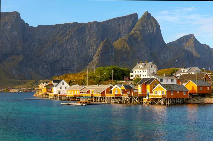 Vibrantly colored clapboard houses nestled by the harbor in the Lofoten Islands.