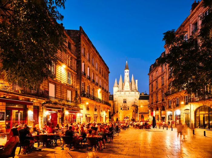 On a warm summer evening, people enjoy sitting outside cafés and bars in the city