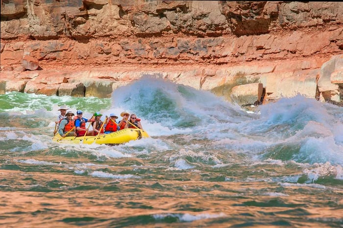 A group navigates a raft through the rapids of Grand Canyon National Park, Arizona, USA