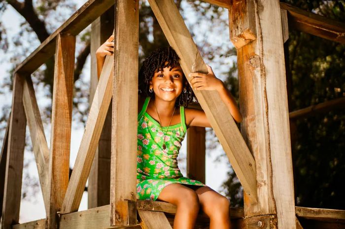 A cheerful girl enjoys a climbing frame in a park in Honduras