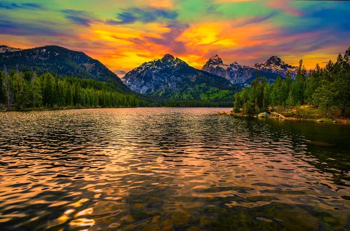 A beautiful sunset over Taggart Lake and the Grand Teton Mountains in Wyoming, USA. Taggart Lake is a breathtaking alpine lake nestled within Grand Teton National Park, surrounded by towering mountains.