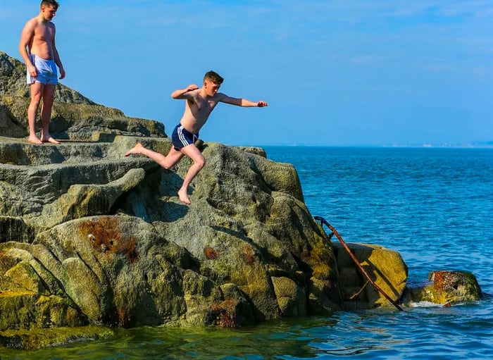 On a sunny Thursday in South Dublin, people take turns leaping off the rocks at the Forty Foot.