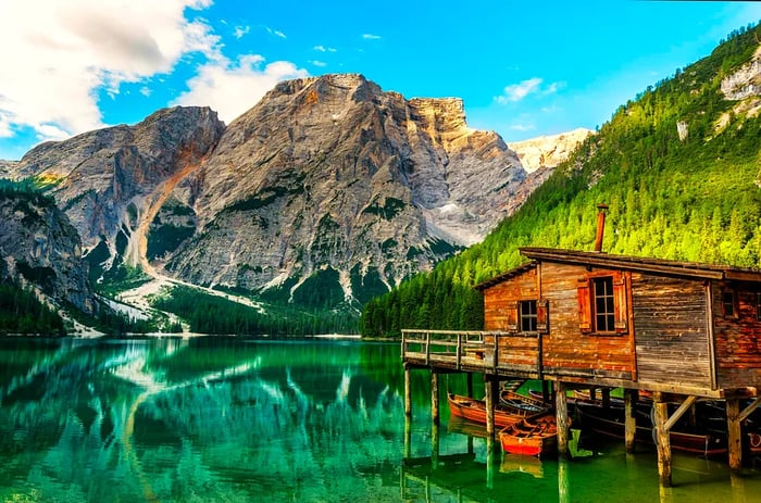 The charming wooden boathouse at Lago di Braies with the majestic Dolomite Mountains behind it