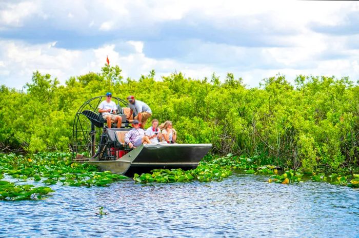 A group of tourists aboard a hovercraft exploring the wetlands of Everglades National Park, Florida, USA