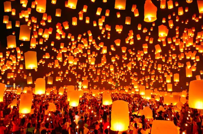 Countless illuminated lanterns drift across the night sky in Thailand during the Loi Krathong festival.