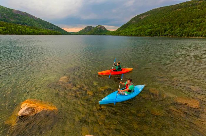 A couple enjoys kayaking on Jordan Pond in Acadia National Park, Maine, USA.