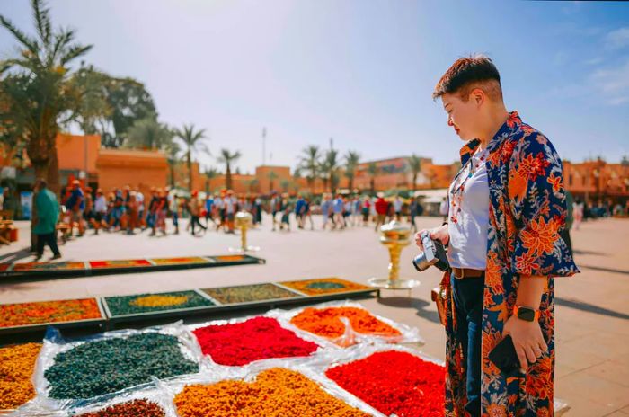 A traveler explores a stall filled with dried flowers in Marrakesh, Morocco.