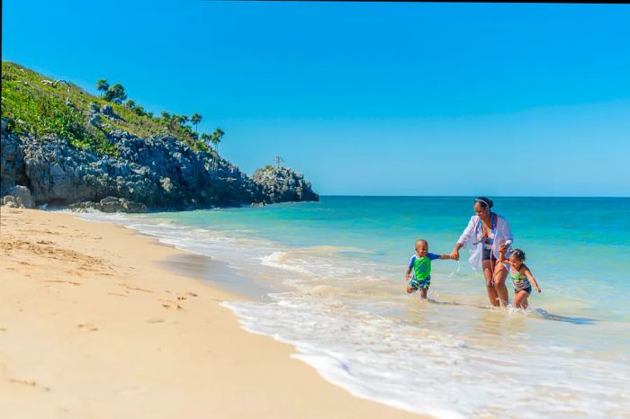 A family enjoying a beach day at the Paya Bay Resort on Roatán, Honduras