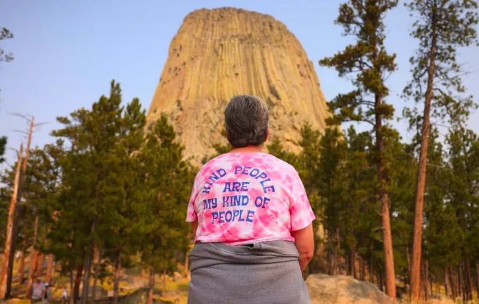 A woman takes a moment to appreciate the view of Devil's Tower as she hikes along the surrounding trail.