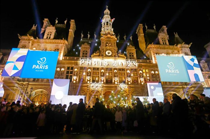 The logo for the Paris 2024 Olympic and Paralympic Games is showcased on the illuminated facade of Paris's town hall, months before the event begins.