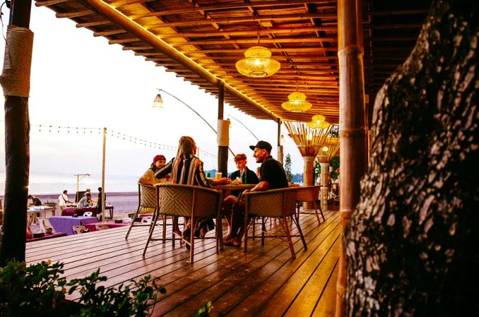 A family of four enjoying a meal at a seaside restaurant