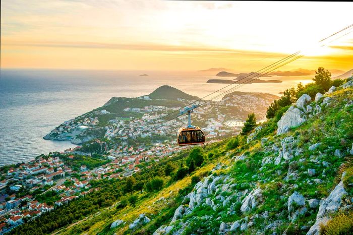 The Dubrovnik cable car descends from Srd hill at sunset