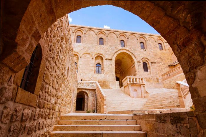 A sandstone-colored monastery framed by an archway