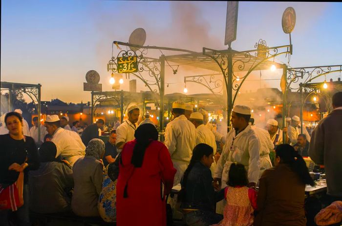 Visitors enjoying meals in Djemaa El Fna square, Marrakesh, Morocco