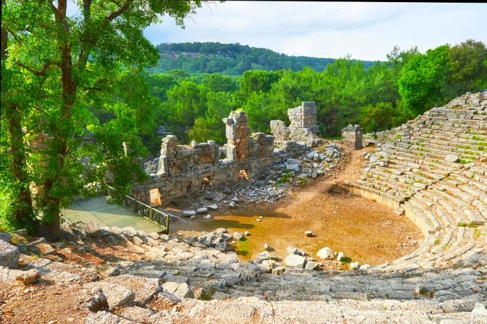 A semi-ruined amphitheater set against a crumbling stone wall