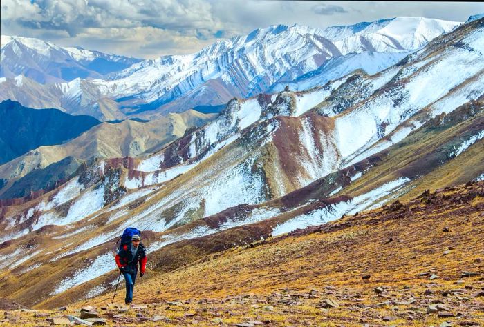 A hiker traversing a desert landscape in Ladakh