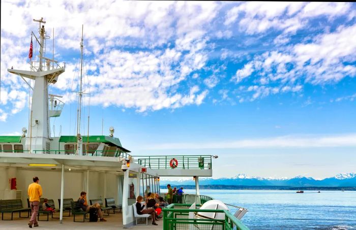 Passengers relax on a ferry as it carries them towards an island.