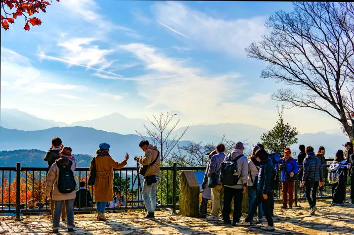 A crowd gathers at a lookout point of Mount Fuji from the summit of Mount Takao (Takao-San).