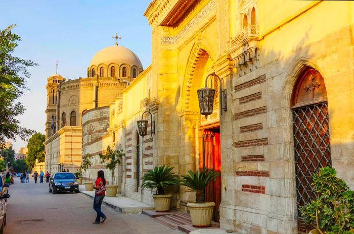 A person walks across the street in front of a church with a distinctive round dome.