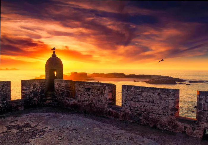 A coastal fortress silhouetted at sunset