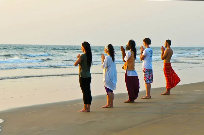 Engaging in yoga on the beach is one of the must-do activities in Goa.