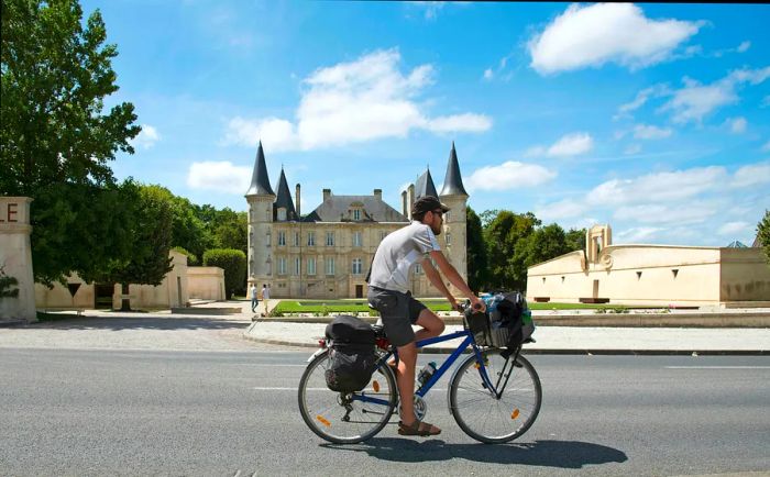 A cyclist passes by Château Pichon Longueville, Pauillac, Gironde, France