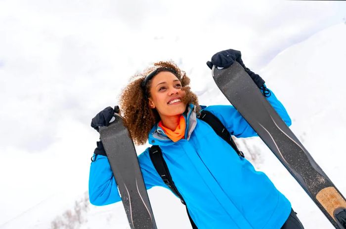 A joyful portrait of a beautiful African American woman skiing outdoors, radiating happiness.