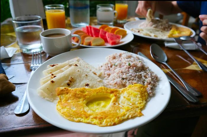 A dish being served in a Maldives restaurant, featuring an omelet and rice.