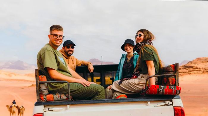 A group of friends enjoying a ride in the back of a 4x4 truck in Jordan